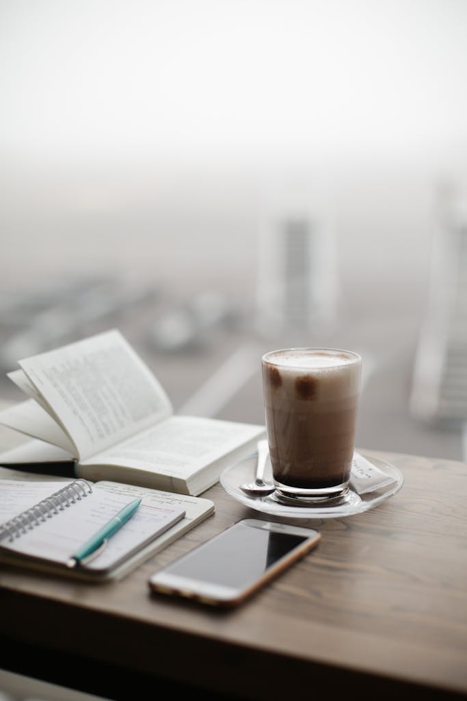 A warm coffee sits beside a notebook and smartphone on a foggy day.
what I’m carrying into the new year