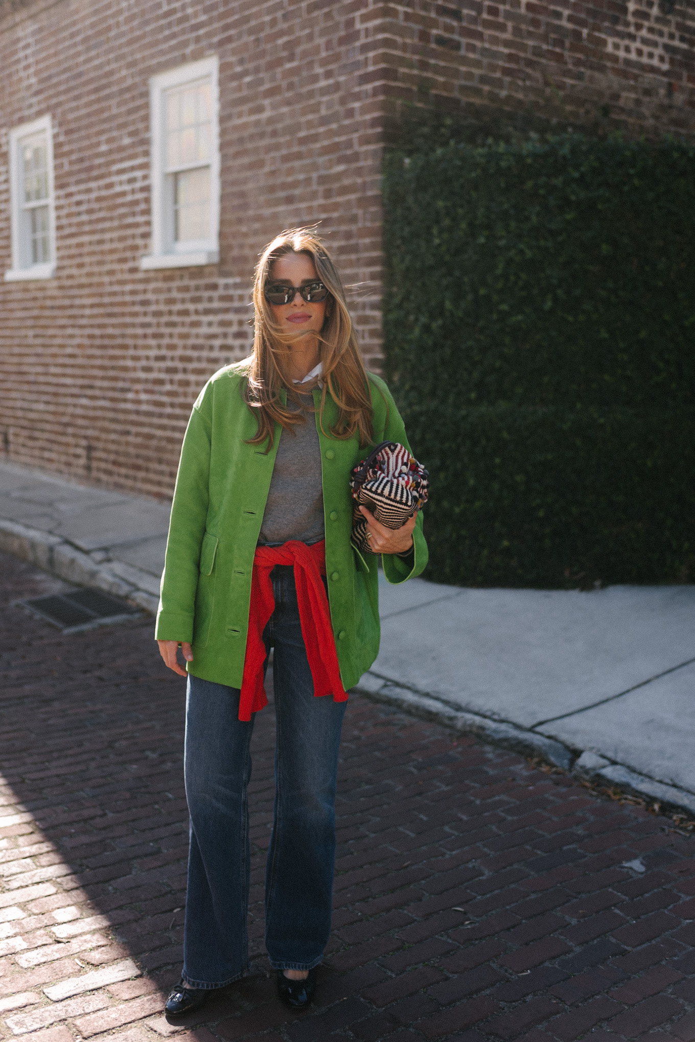 green suede jacket grey wool sweater red cashmere sweater wide leg denim black flats