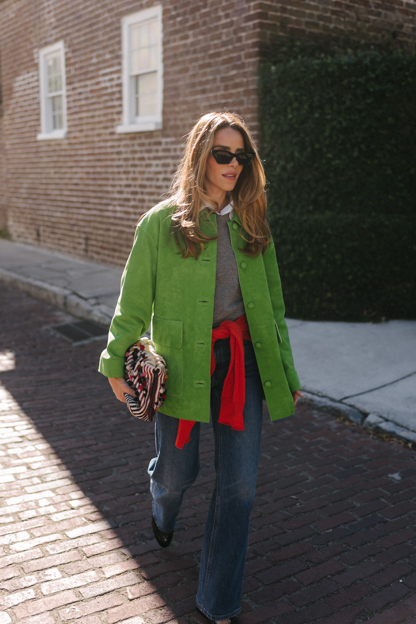 green suede jacket grey wool sweater red cashmere sweater wide leg denim black flats