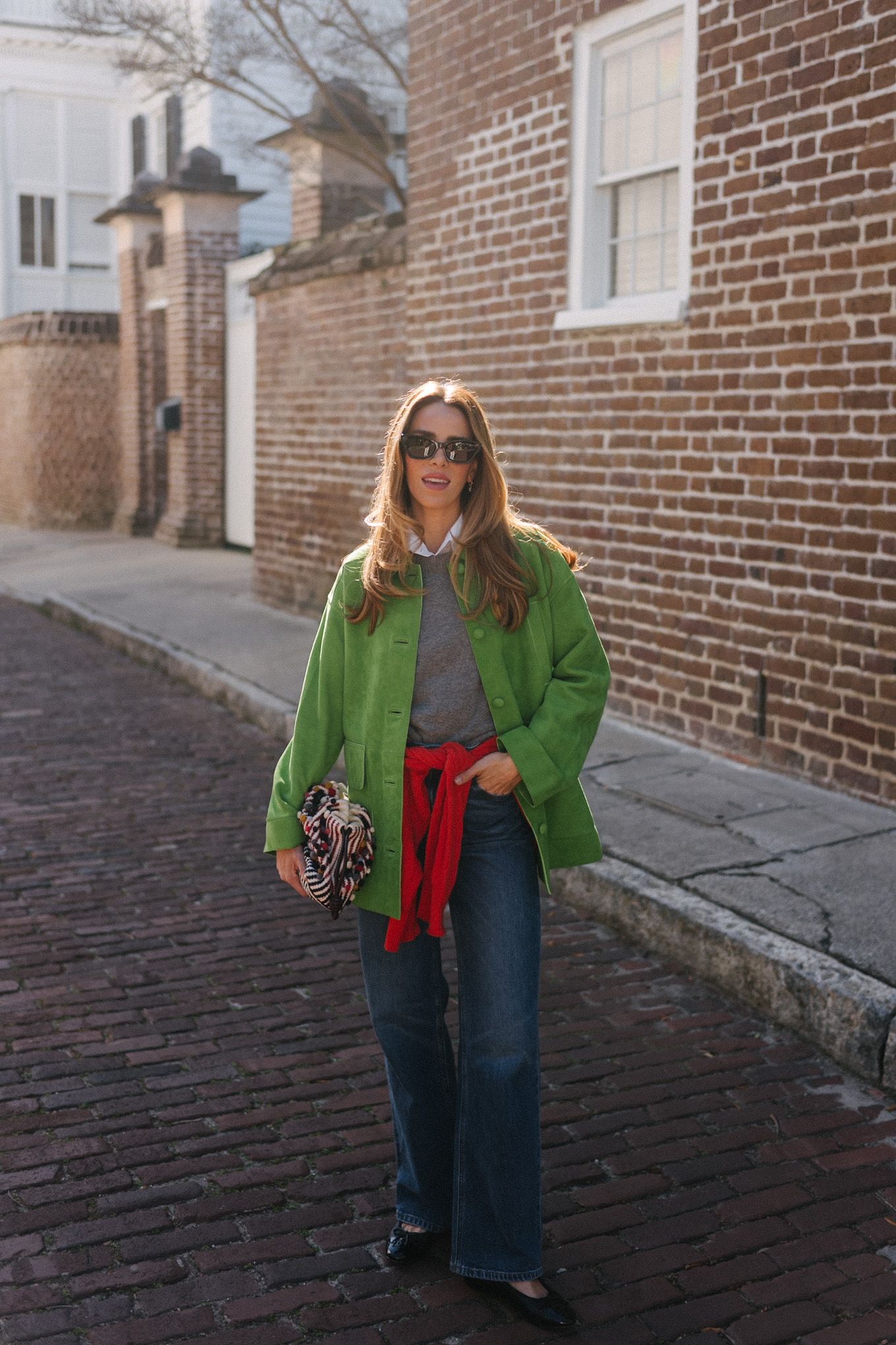 green suede jacket grey wool sweater red cashmere sweater wide leg denim black flats