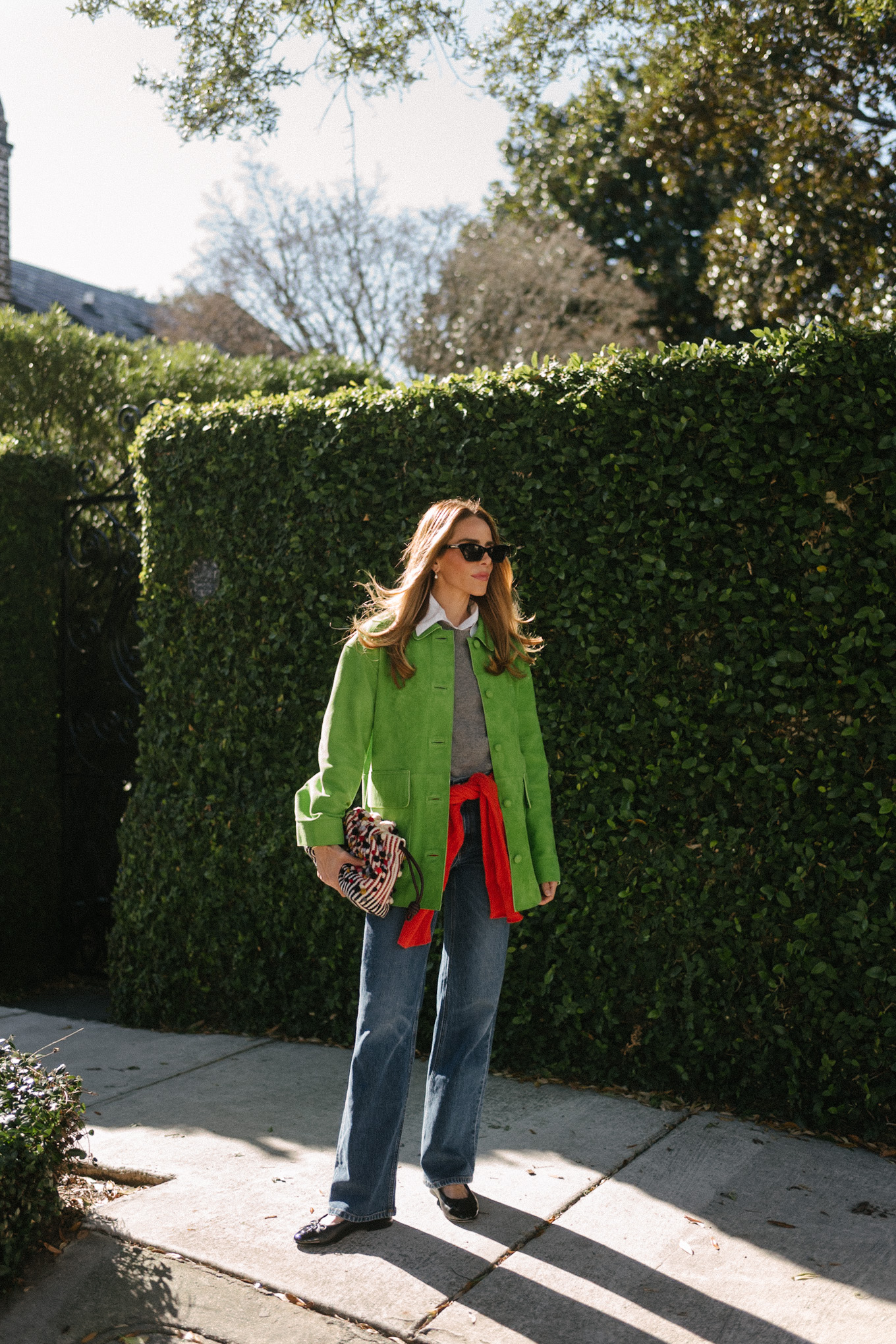 green suede jacket grey wool sweater red cashmere sweater wide leg denim black flats