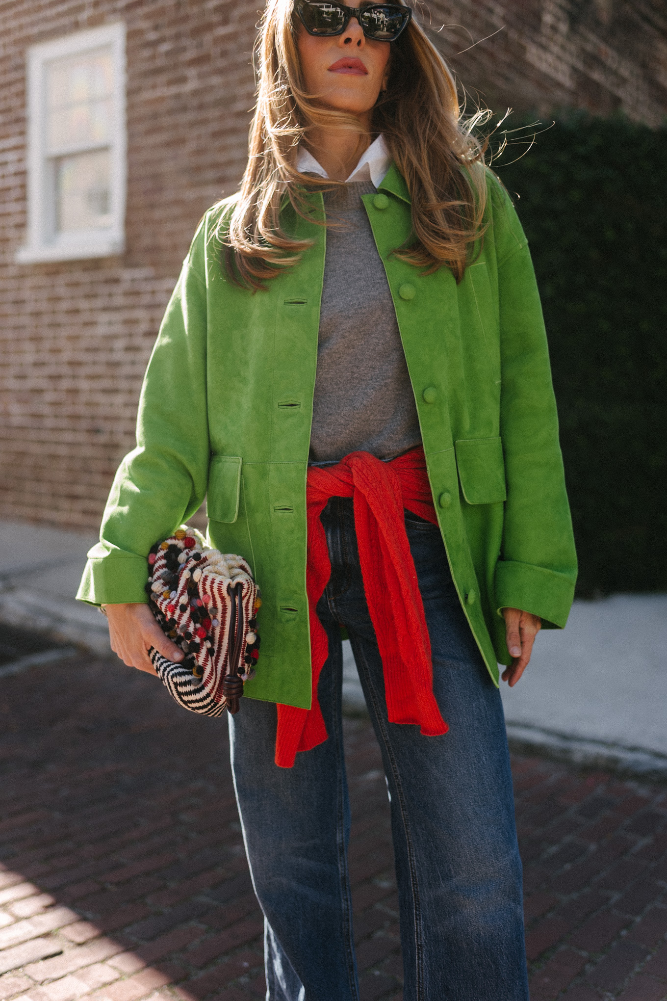 green suede jacket grey wool sweater red cashmere sweater wide leg denim black flats