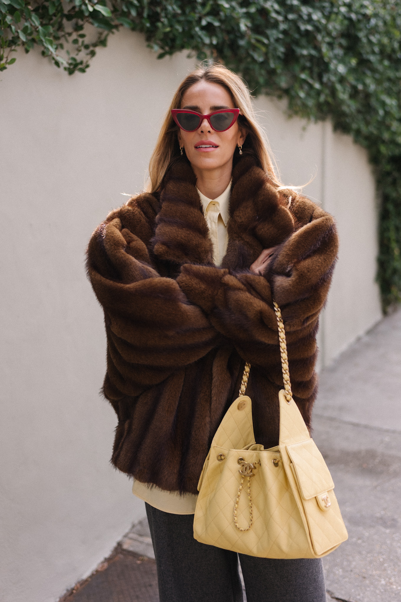 brown faux fur coat yellow button down shirt grey pants yellow tote red flats