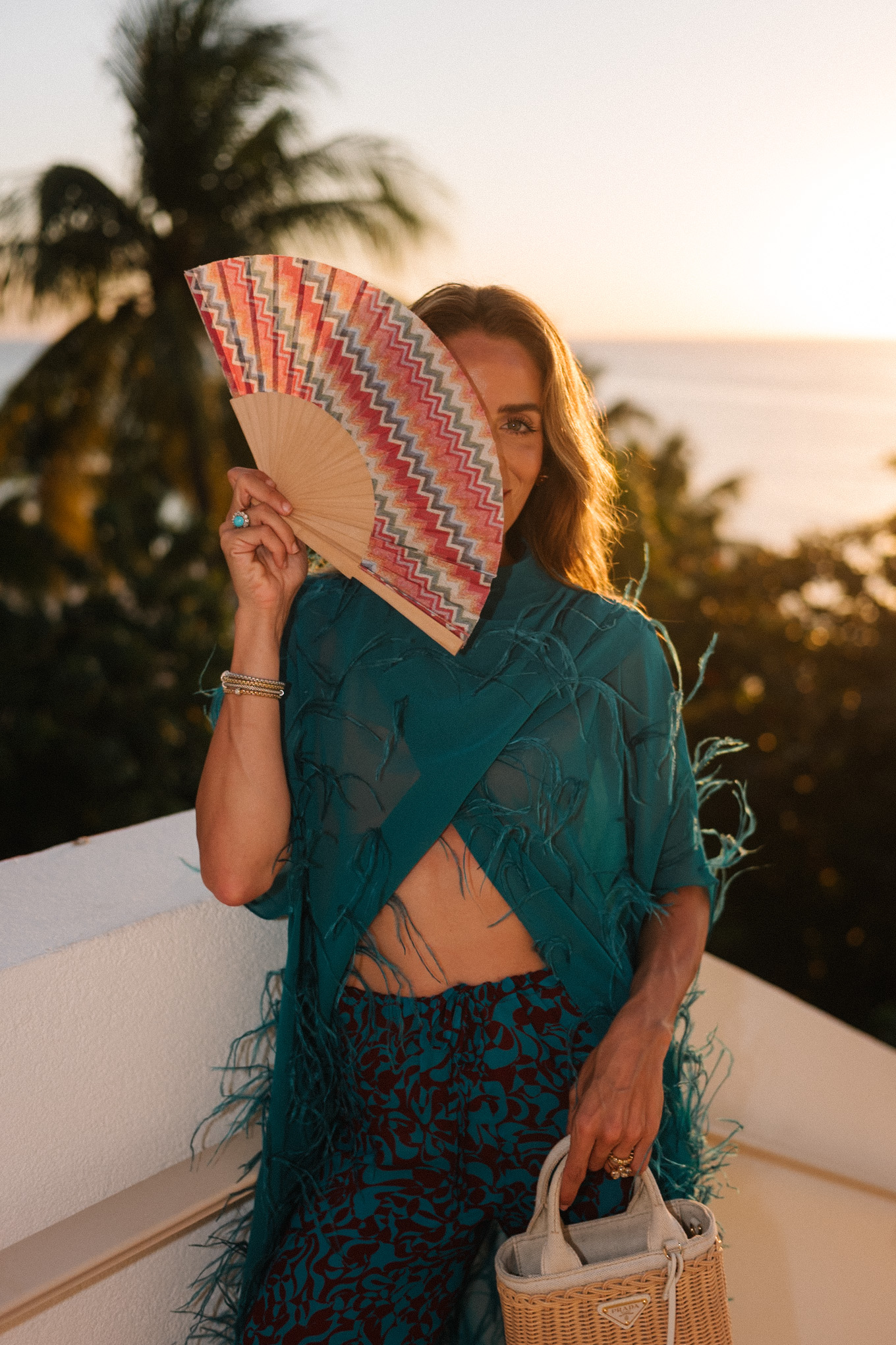 turquoise feathered maxi top turquoise printed wide leg pants wicker handbag