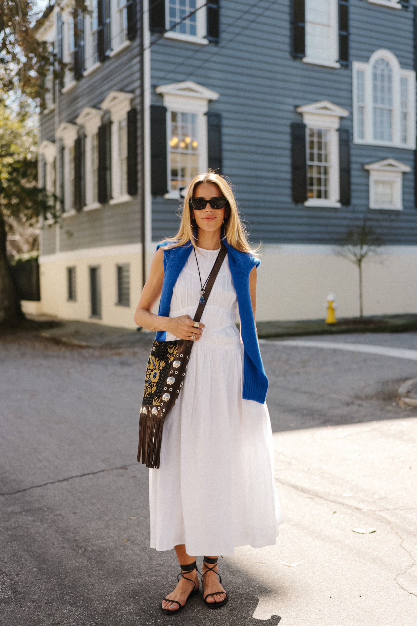 white maxi dress blue sweater fringe suede bag