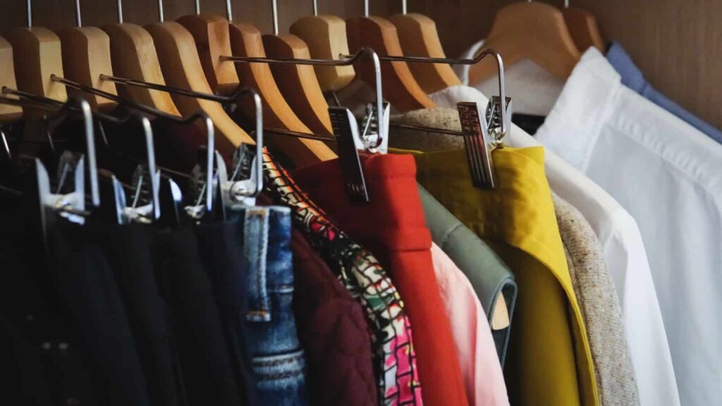 A colorful capsule wardrobe hanging in closet. Image credit Alxcrs via Shutterstock